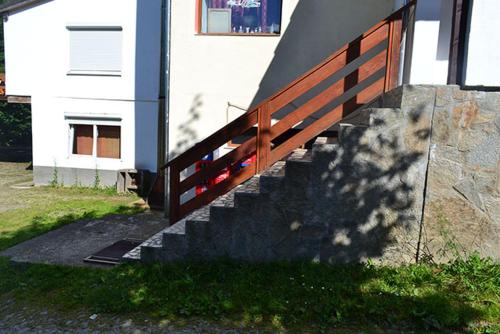 a staircase with a wooden fence next to a house at Pensiunea Daniels in Văliug