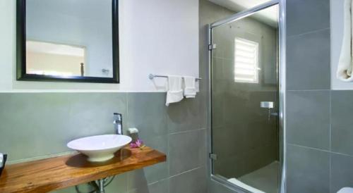 Merrils Deluxe في نيغريل: حمام مع حوض ودش زجاجي