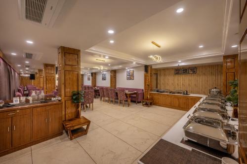 un ristorante con un bar con tavoli e sedie di Echor KC Grand Kufri a Fagu