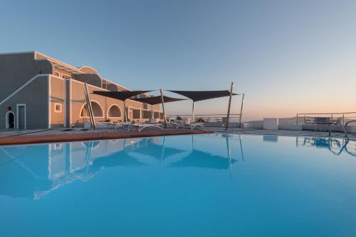 a large swimming pool next to a building at Caldera's Dolphin Suites in Megalokhori