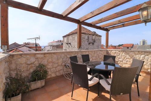 a patio with a table and chairs on a stone wall at Downtown stone house in Vodice