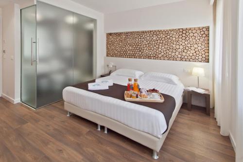 a hotel room with a bed with a tray of food on it at Biafora Resort & Spa in San Giovanni in Fiore