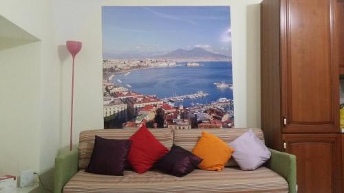 ナポリにあるSognando Napoliの絵画が飾られた客室内のソファ(カラフルな枕付)