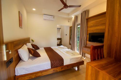 a bedroom with a bed and a television in a room at Grand Victoria in Erumeli