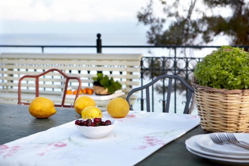 a table with a plate of fruit and a bowl of fruit at Avra Private Suites in Lassi