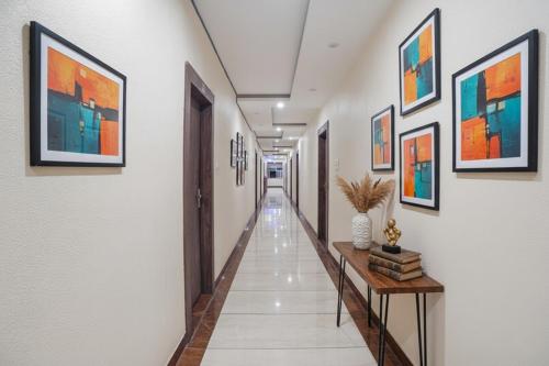 a corridor of a hallway with paintings on the walls at FabHotel The Pannis in Bhopal