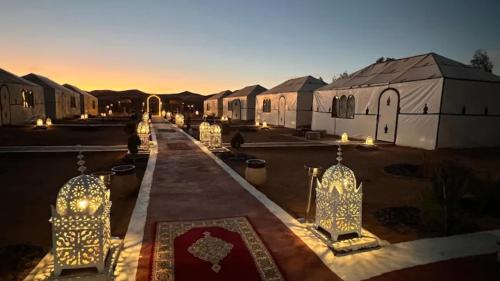 a group of buildings with lights in a courtyard at Experience Luxury Desert Camp in Merzouga