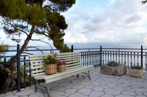 a white bench with two baskets of flowers on it at Avra Private Suites in Lassi