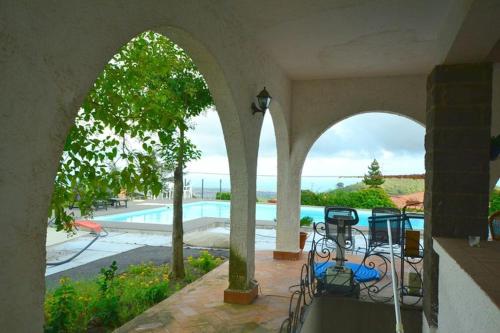 an outdoor patio with a swimming pool in a house at Villa MariÆtna in Trecastagni