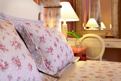 a bed with pink pillows and a table with a lamp at Avra Private Suites in Lassi
