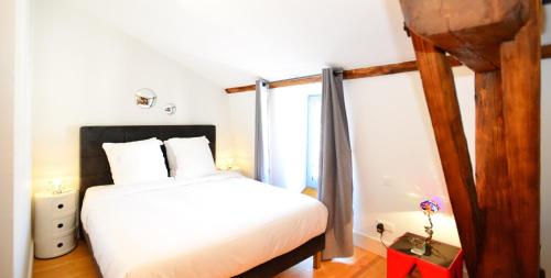 ein Schlafzimmer mit einem weißen Bett und einem Fenster in der Unterkunft Appart' Lyonnais in Lyon