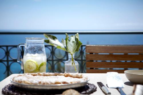 a table with a pie and a vase with a drink at Avra Private Suites in Lassi