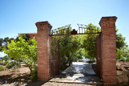 an entrance to a brick archway with an iron gate at Avra Private Suites in Lassi