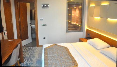 a bedroom with a bed and a bathroom with a window at Panaroma Damla Otel in Samsun