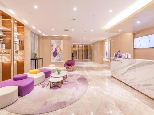 a lobby with purple and white furniture in a building at Lavande Hotel Ji'nan Railway Station Long Distance Bus Terminal in Jinan