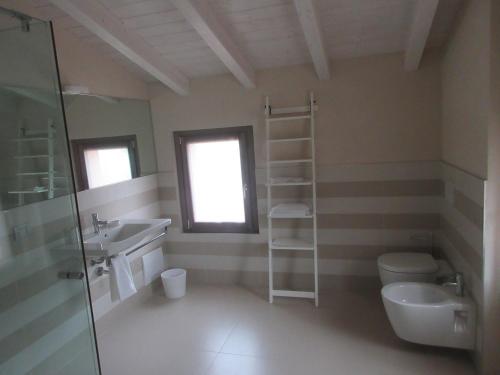 a bathroom with a sink and a toilet and a mirror at Villa Laura in Cocconi
