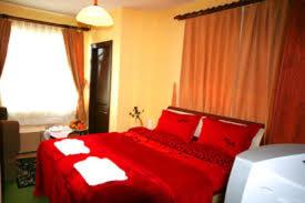 a red bed with red pillows in a bedroom at Gizlibahce Hotel in Karaburun
