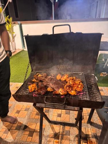 a grill with a bunch of food on it at Hakeem Homestay in Pokok Sena