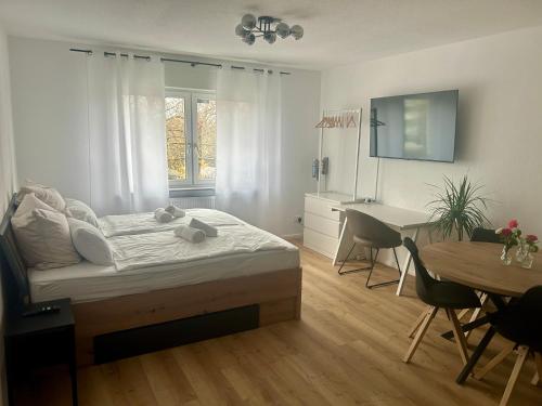 Un dormitorio con una cama, un escritorio y una mesa. en Pfalz-Studio in Speyer - stilvoll, modern & zentral, en Speyer