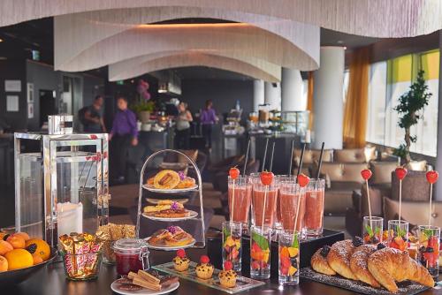 a buffet with different types of food on display at INNSiDE by Meliá Düsseldorf Hafen in Düsseldorf