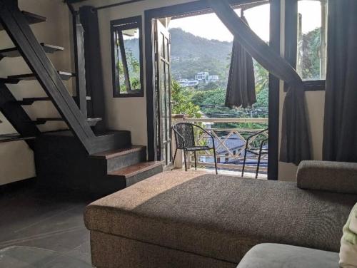 Cette chambre dispose d'un canapé et d'un balcon avec vue. dans l'établissement My Dream Wedding Apartments, à Nathon Bay