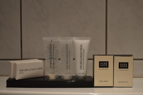 a shelf with three products on it in front of a mirror at Hotel Royal Zelzate in Zelzate