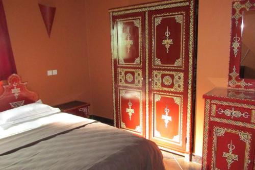 a bedroom with a large wooden door and a bed at Villa La Zitoune in Aghmat