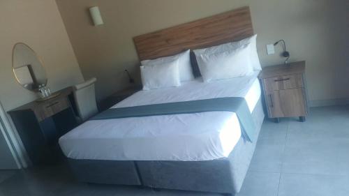 a bedroom with a large bed and a mirror at Fikani game lodge in Thabazimbi