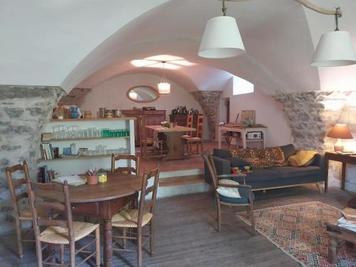 a living room with a table and a couch at Maison Authentique en Ubaye in Jausiers