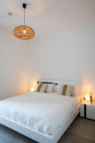 a bedroom with a large white bed with a chandelier at Desert Retreat Canal View walk to F1 Yas Island in Abu Dhabi