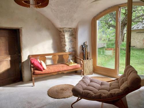 a living room with a couch and a window at Maison Authentique en Ubaye in Jausiers