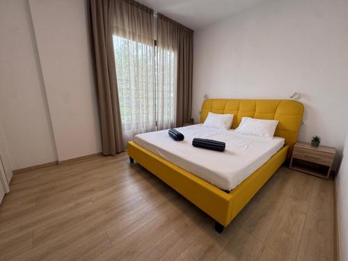 a bedroom with a bed with a yellow headboard and a window at Modern 3 bedroom villa with pool in Paphos