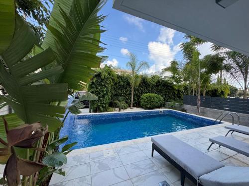 a swimming pool in a yard with a bench next to it at Modern 3 bedroom villa with pool in Paphos City