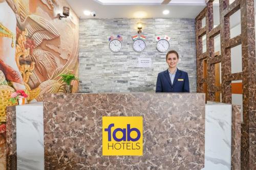 a man standing behind a podium with aida hotels sign at FabHotel Sirtaj Suits in Agra