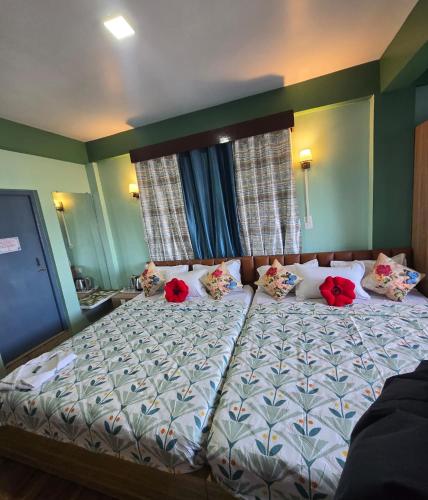 een slaapkamer met een bed met rode bloemen erop bij Sonali Megh in Darjeeling