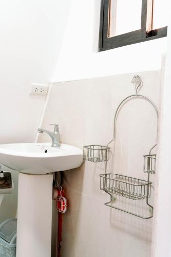 a bathroom with a sink and two baskets on the wall at Filmegs Seaside in Alegria