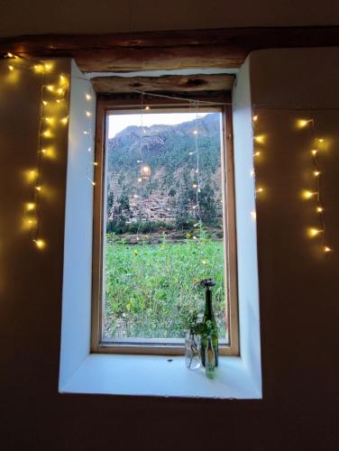 ein Fenster mit einer Flasche auf einem Sims mit Aussicht in der Unterkunft Loft acogedor in Ollantaytambo