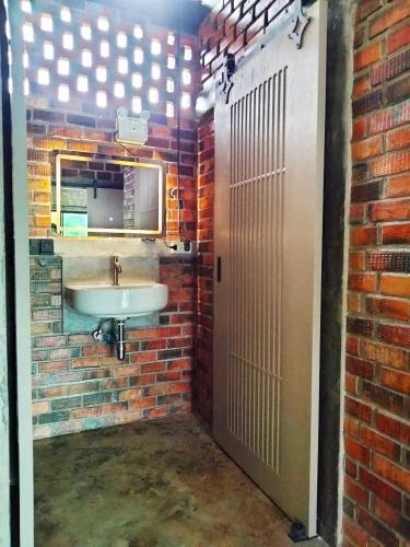 a bathroom with a sink and a brick wall at Baan Malee Villa in Ko Lanta