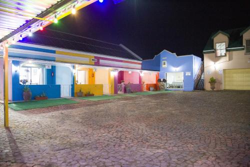a colorful building with lights on it at night at Storms River Self Catering Apartments in Stormsrivier