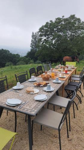 une longue table en bois avec des chaises et de la nourriture dessus dans l'établissement La Parenthèse, à Saint-Genix-sur-Guiers