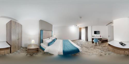 een slaapkamer met een groot bed en een bureau bij Royal Hotel & Events in Băileşti