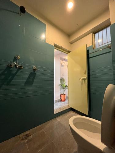 een badkamer met een groene muur, een badkuip en een toilet. bij Front Stupa View in Kathmandu
