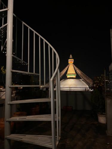 Front Stupa View في كاتماندو: مبنى يعلو سطحه برج.