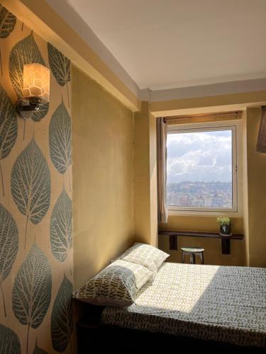 een kleine slaapkamer met een bed en een raam bij Front Stupa View in Kathmandu