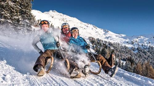 un groupe de trois personnes à bord d'une motoneige dans l'établissement Panorama Wildgrat, à Wenns
