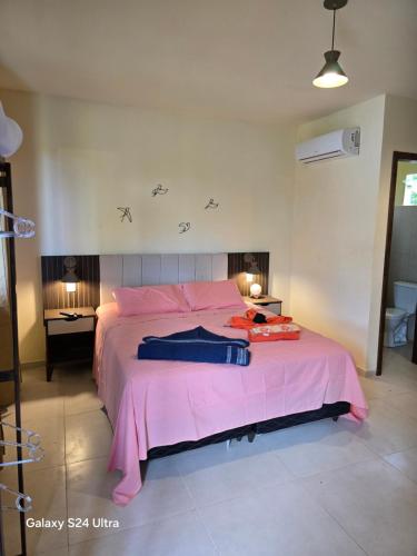 a bedroom with a large pink bed with pink sheets at Lá vie taipu in Marau