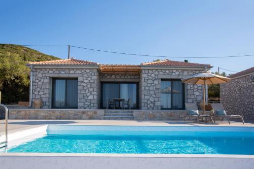a villa with a swimming pool in front of a house at Ionian Harmony in Tsoukaladhes