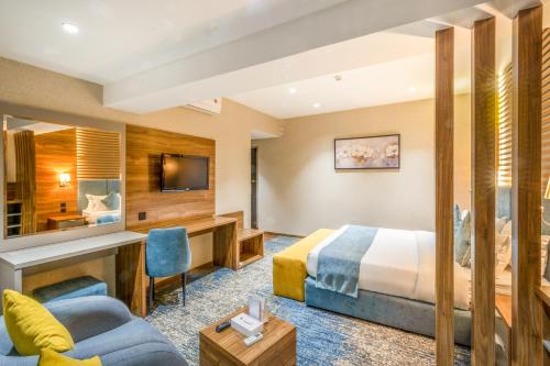 a hotel room with a bed and a desk at Almsakn Alola Hotel Company in Riyadh