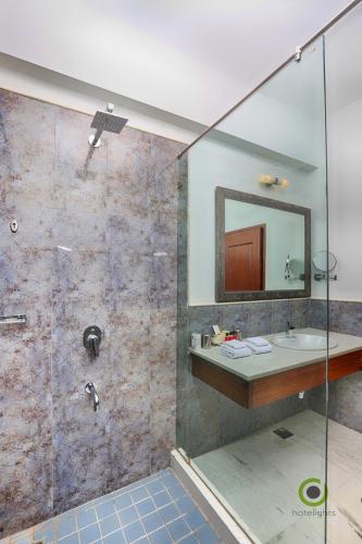 a bathroom with a sink and a shower with a mirror at Fateh Niwas by Fateh Collection in Udaipur