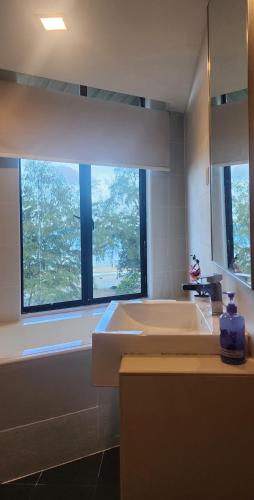 a bathroom with a large white tub and a window at Samsuria Beach Resort Penthouse in Cherating